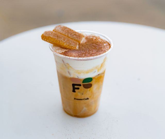 Tiramisu Latte topped with mascarpone cream and a ladyfinger