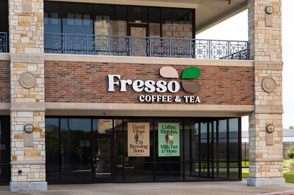 The Fresso Coffee and Tea storefront: white lettering and the three-petal mark on a brick and limestone building